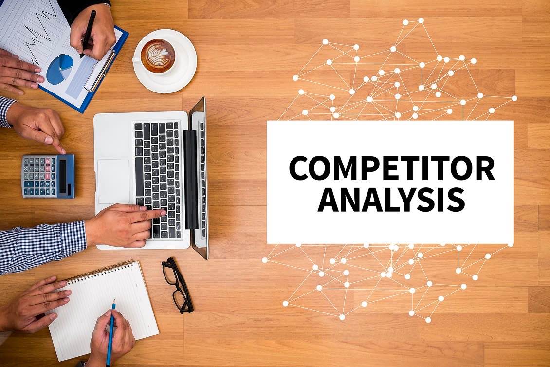 Competitor analysis workshop with market data, laptop and planning materials